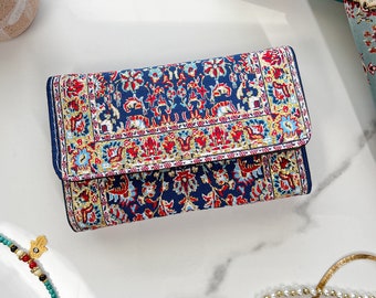 May include: A blue and red patterned wallet with a gold trim. The wallet is made of fabric and has a traditional design.