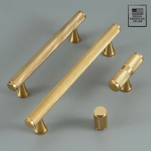 May include: Set of five gold-toned cabinet hardware pulls with a textured finish. The set includes two long pulls, one short pull, and two knobs.