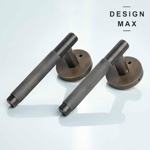 May include: Two antique bronze door handles with a textured, cylindrical design. The handles have a round base with a keyhole.
