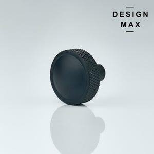 May include: Black metal knob with a diamond pattern around the edge. The knob has a round, flat top.