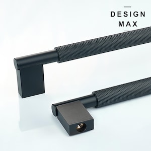 May include: Black cabinet hardware with a textured finish. The hardware has a square base and a long, cylindrical handle. The text "DESIGN MAX" is visible in the top right corner of the image.