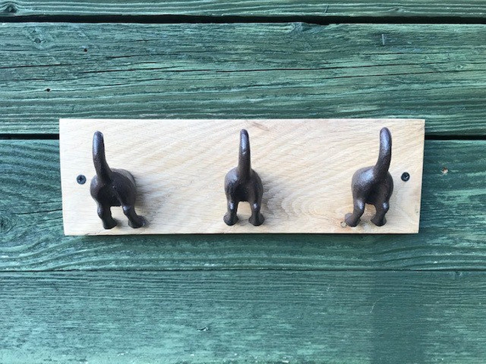 Cast iron dog tail hooks on a waxed oak plinth Etsy.de
