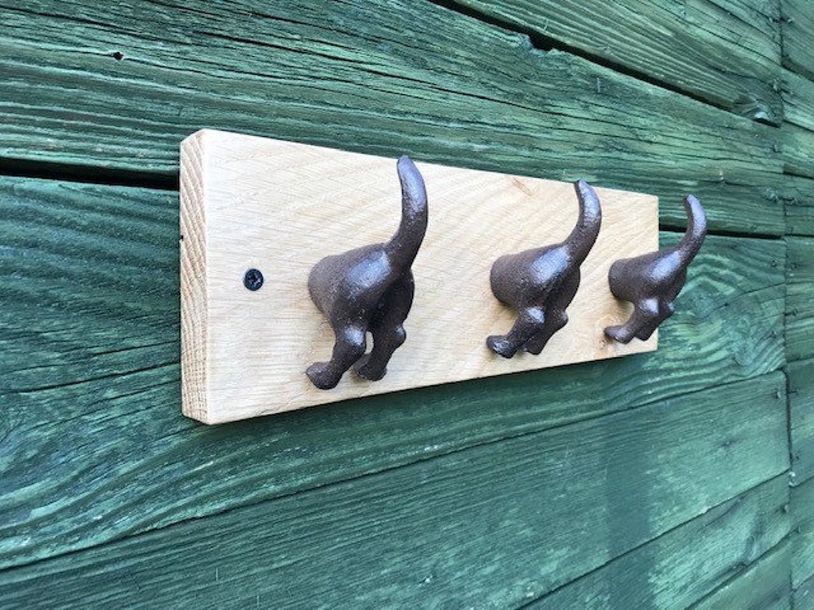 Cast iron dog tail hooks on a waxed oak plinth Etsy.de