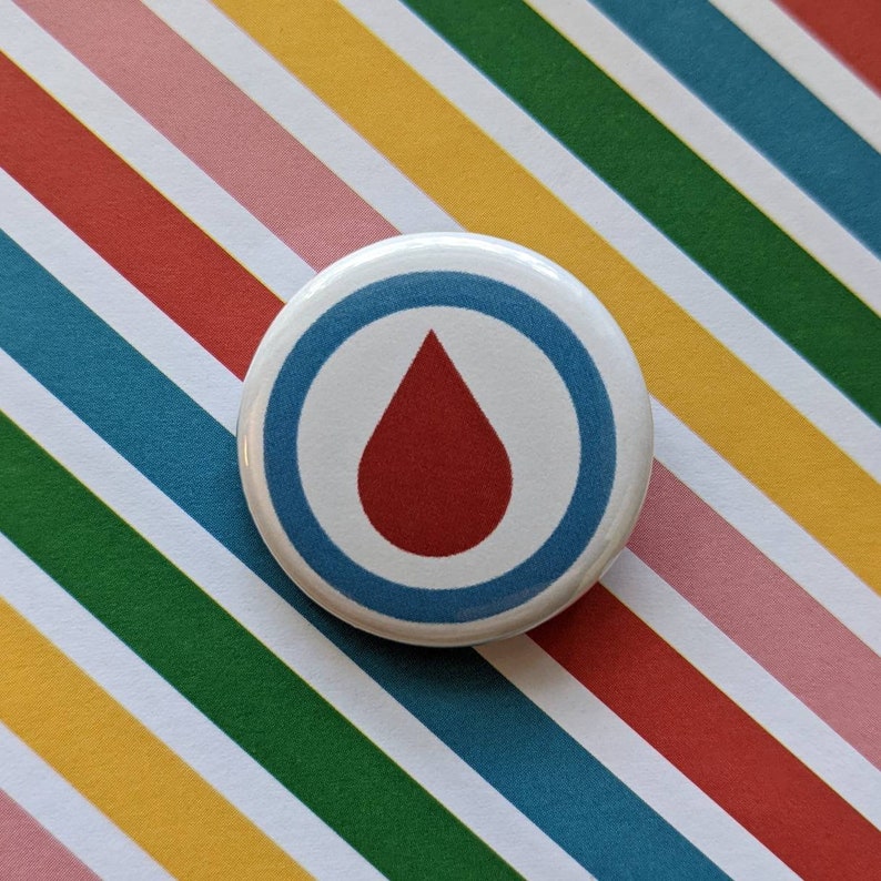 May include: A white button with a blue circle and a red drop inside. The button has a white background and a blue border.
