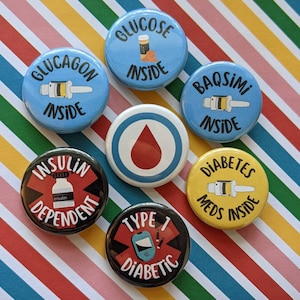 May include: Seven round blue, yellow, and black buttons with white text and images. The buttons feature medical terms like "Glucose Inside", "Insulin Dependent", "Type 1 Diabetic", and "Diabetes Meds Inside".
