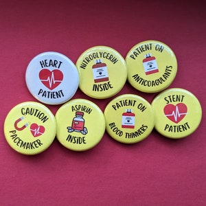May include: Eight yellow button badges with medical information. The badges feature red hearts, pills, and text such as "Heart Patient", "Aspirin Inside", "Patient on Blood Thinners", and "Stent Patient".