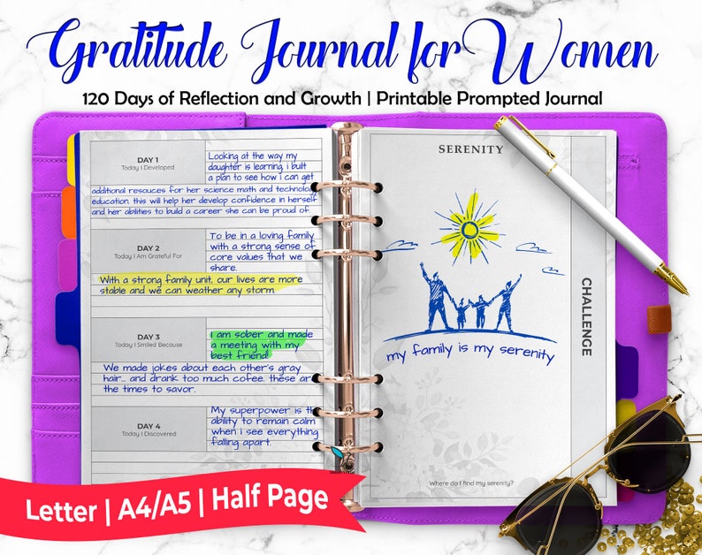 May include: A purple journal with a gold ring binder. The journal is open to a page with a daily gratitude prompt. The page is decorated with a drawing of a family and the words "my family is my serenity".
