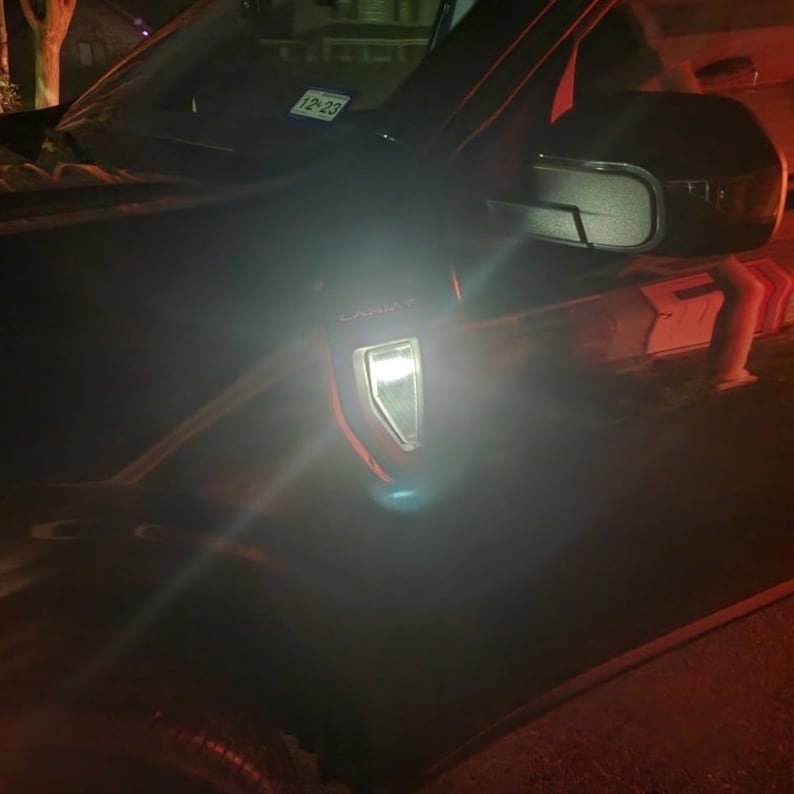 May include: A black car with a white light on the side. The car has a "Limited" emblem on the side.