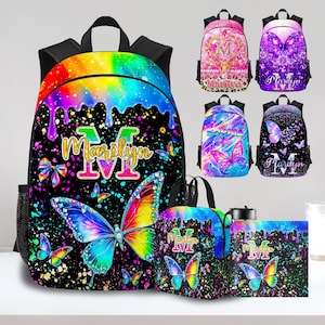 May include: A collection of personalized backpacks, lunch bags, and accessories featuring a vibrant butterfly design. The main backpack has a rainbow drip effect with the name "Marilyn" and a large butterfly. Additional backpacks showcase different butterfly and name designs.