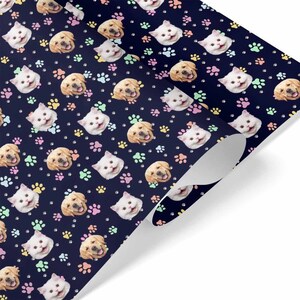 May include: A blue wrapping paper with a repeating pattern of cat and dog faces and paw prints in pink, yellow, and green.