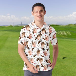 Może przedstawiać: Biała koszulka polo z powtarzającym się wzorem twarzy dziecka, kij&oacute;w golfowych, toreb golfowych i piłek golfowych. Koszula ma kr&oacute;tkie rękawy i kołnierzyk. Tło to zielone pole golfowe.