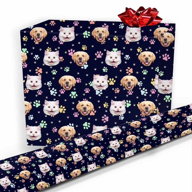 May include: Blue wrapping paper with a repeating pattern of paw prints, cat faces, and dog faces. The paper is wrapped around a gift box with a red bow.