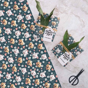 May include: A sheet of wrapping paper with a repeating pattern of dog and cat faces, pink hearts, white paw prints, and white bones on a dark teal background. The text "Thank You You Are Awesome" is on a white tag.