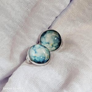 Pendientes de clip con diseño de acuarela azul: tono plateado, no requieren perforación.