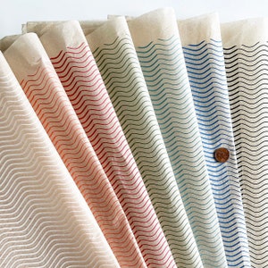 May include: A set of eight sheets of wrapping paper with a wavy line pattern in various colors, including white, orange, red, green, blue, and black.