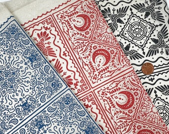 Könnte beinhalten: Drei Stoffmuster mit verschiedenen Bandanamustern. Das erste Muster hat ein blaues Paisley-Muster, das zweite ein rot-weißes Muster mit Halbmonden und floralen Designs und das dritte ein schwarz-weißes Muster mit einem Vogeldesign.