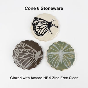 May include: Three ceramic coasters with a butterfly design. The coasters are glazed with Amaco HF-9 Zinc Free Clear glaze. Cone 6 stoneware.