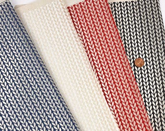 May include: Four strips of fabric featuring a repeating vertical knit stitch pattern in blue, off-white, red, and black. A copper-colored penny is placed on the black fabric strip to provide a sense of scale for the printed design.