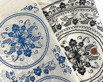 Könnte beinhalten: Zwei Stoffstücke mit weißem Hintergrund und blauen und schwarzen Blumenmustern. Die Muster sind kreisförmig und weisen komplizierte Designs auf.