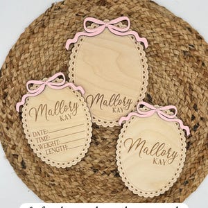 Puede incluir: Tres placas ovaladas de madera con bordes festoneados y lazos rosas. Las placas est&aacute;n grabadas con el nombre "Mallory Kay". Una placa incluye l&iacute;neas para la fecha, la hora, el peso y la longitud. El texto "Matching files sold separately" est&aacute; en la parte inferior.
