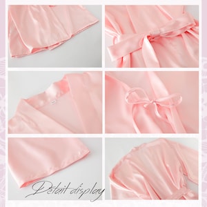 May include: A pink satin robe with a tie belt and long sleeves. The robe is shown in detail, including the neckline, the tie belt, and the sleeves.