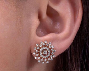 May include: A pair of gold stud earrings with a circular design featuring a cluster of small, clear diamonds.