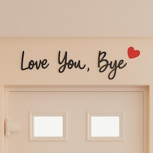 Puede incluir: Texto negro en cursiva que dice "Love You, Bye" con un símbolo de corazón rojo. El texto está montado sobre una puerta blanca con dos ventanas rectangulares.