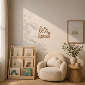May include: A children's reading corner with a wooden bookshelf holding books, a cream armchair with a cloud cushion, and a wooden sign saying "let's read". A framed print with the text "So many books, so little time" is on the wall. The room has a warm, inviting atmosphere.