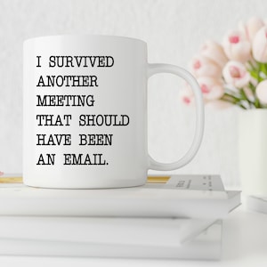 May include: White ceramic mug with black text that reads "I survived another meeting that should have been an email."