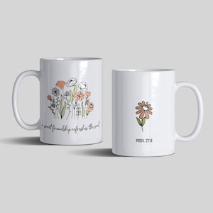 Puede incluir: Dos tazas de cerámica blanca con un diseño floral. Una taza presenta un grupo de flores con el texto "a sweet friendship refreshes the soul". La otra taza presenta una sola flor con el texto "PROV. 27.9".