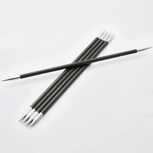 Op de afbeelding: Een set donkergrijze breinaalden met zilveren punten. De naalden zijn in een kruispatroon gerangschikt tegen een witte achtergrond. De naalden lijken van een glad materiaal te zijn gemaakt. Elke naald is ongeveer 30 cm lang.