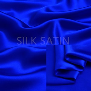 Peut inclure: Un gros plan sur un tissu de satin de soie bleu royal lisse. Le tissu est drapé et plié, mettant en valeur sa texture luxueuse et sa couleur riche.