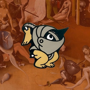 May include: A gray and black enamel pin depicting a cartoon character wearing a helmet and holding a sword. The character is in a crouching position and has a yellow body.