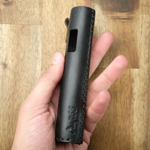 May include: Black leather case with a stitched design and the text "The Vape Life" on the side.