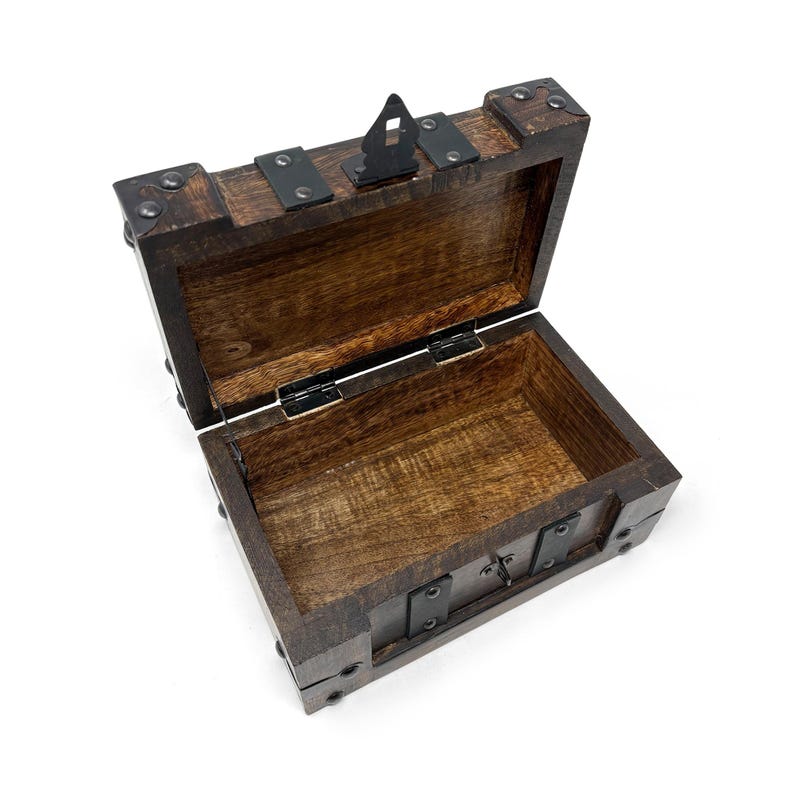 May include: An open, antique-style wooden chest with dark brown stain. The chest features metal hinges, corner brackets, and a latch. The interior is a lighter shade of brown, and the chest is empty.