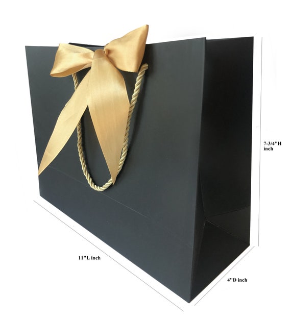 Premium Photo  A gift wrapped in black paper and tied with a gold ribbon.  expensive gift concept.