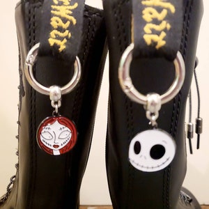 May include: A pair of black leather boots with silver metal charms attached to the laces. The charms are of Sally and Jack Skellington from The Nightmare Before Christmas.