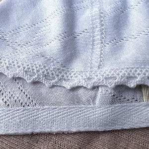 Newborn baby bonnet in white with lace. image 1