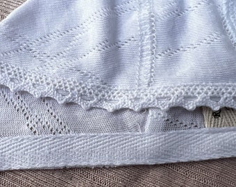 Newborn baby bonnet in white with lace.