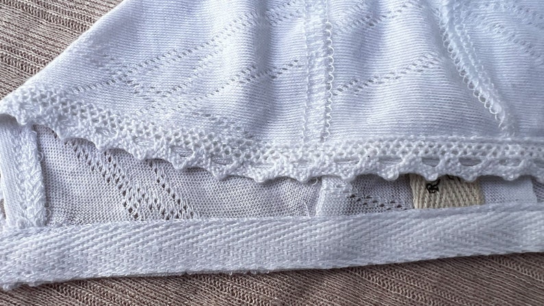 Newborn baby bonnet in white with lace. image 1