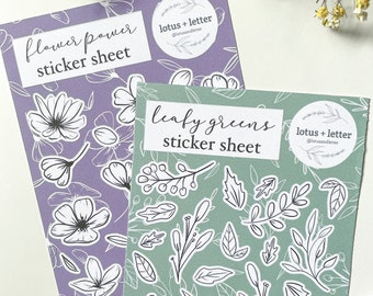 May include: Two sticker sheets, one with a purple background and flower designs, and the other with a green background and leafy designs. Both sheets have the text "lotus + letter" and "sticker sheet" on them.