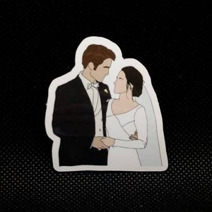 Puede incluir: Una ilustración en blanco y negro de una pareja con atuendo de boda. El novio lleva un traje negro con camisa blanca y corbata de lazo negra. La novia lleva un vestido blanco con velo. Se miran y sonríen.
