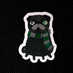 Könnte beinhalten: Ein Aufkleber mit einem Cartoon-Mops mit schwarzem Fell, grünen Augen und einem grau-grünen gestreiften Schal. Der Mops sitzt aufrecht. Der Aufkleber hat einen weißen Rand.