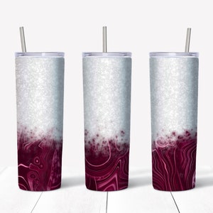 May include: Three stainless steel tumblers with a white glitter finish and a burgundy swirl design. The tumblers have lids and straws.