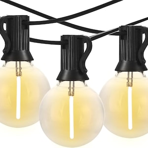 May include: String of three round, frosted light bulbs with a warm yellow glow. Each bulb is connected to a black wire and has a black fixture. The bulbs are evenly spaced and appear to be for outdoor use.