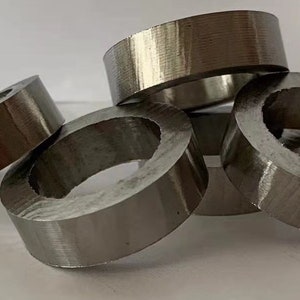 May include: Five silver metal rings stacked on top of each other. The rings are all the same size and have a smooth, polished finish.