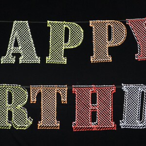 May include: A colorful Happy Birthday banner with a mesh-like design. The letters are in different colors, including green, yellow, orange, red, and blue.