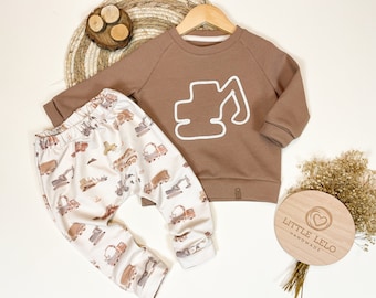 Conjunto de ropa hecho a mano: suéter con motivo de cordón de excavadora y pantalón a juego.