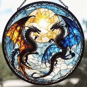 Może przedstawiać: Witraż przedstawiający dwa czarne smoki z pomarańczowymi i niebieskimi skrzydłami, stojące naprzeciwko siebie przed żółtym księżycem.