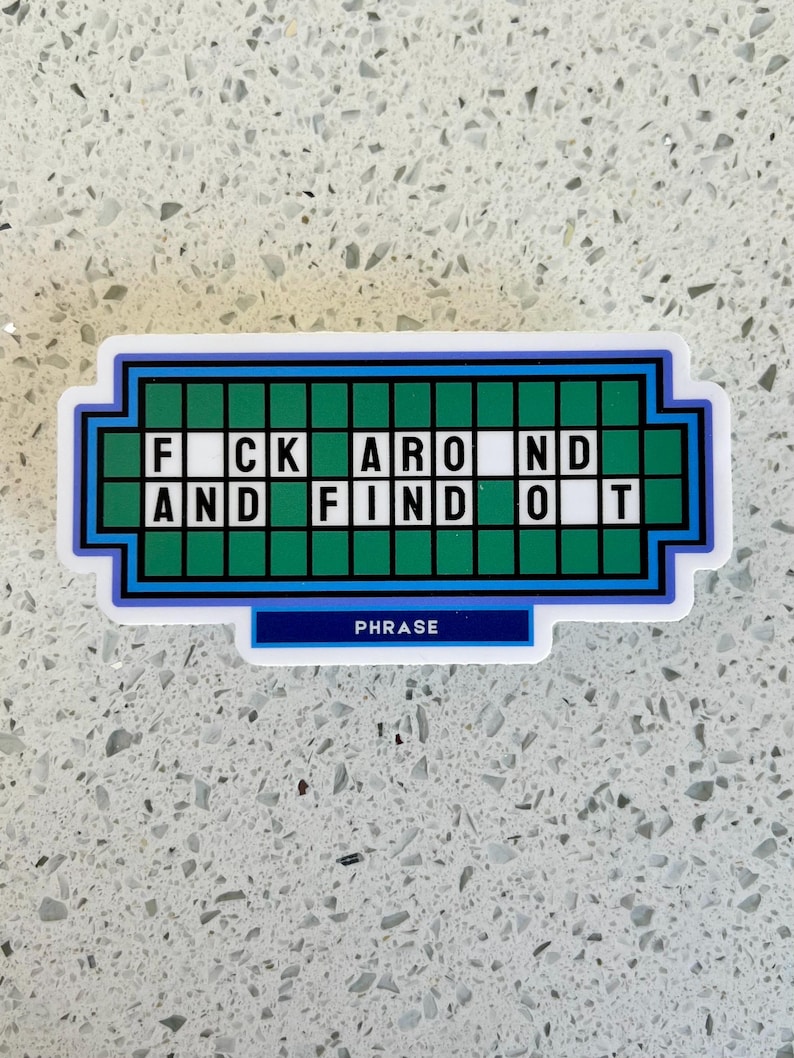 May include: A sticker with a design resembling a game show puzzle board. The phrase "F*CK AROUND AND FIND OUT" is spelled out in white letters on a green background. The word "PHRASE" is written in white on a blue banner.